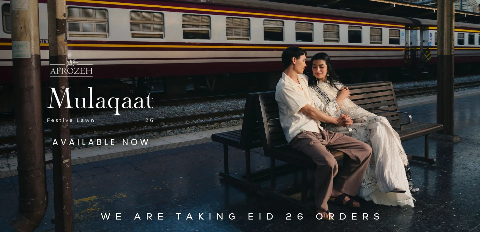 Two people sitting on a bench at a train station with promotional text for 'Mulaqaat' and 'Afrozeh Eid Dresses'.