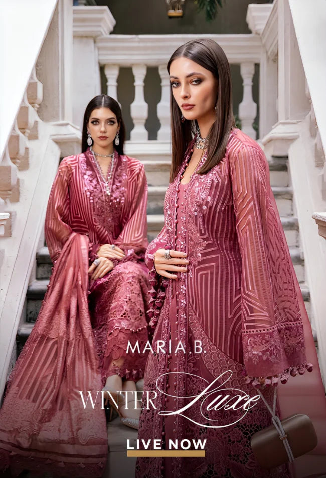 Two women in pink embroidered dresses on a staircase with 'Maria B. Winter Luxe' branding.